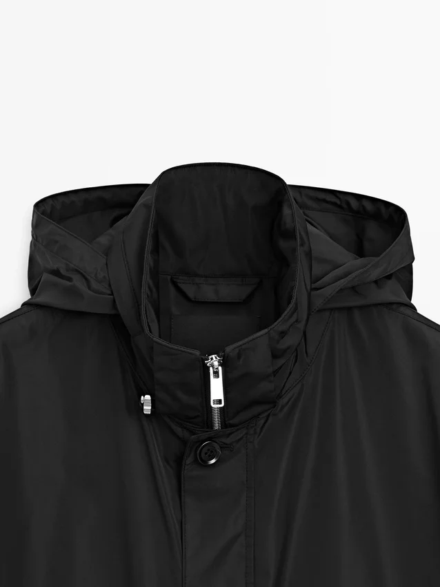 Parka med hette og stoffdetaljer Parka med hette og stoffdetaljer