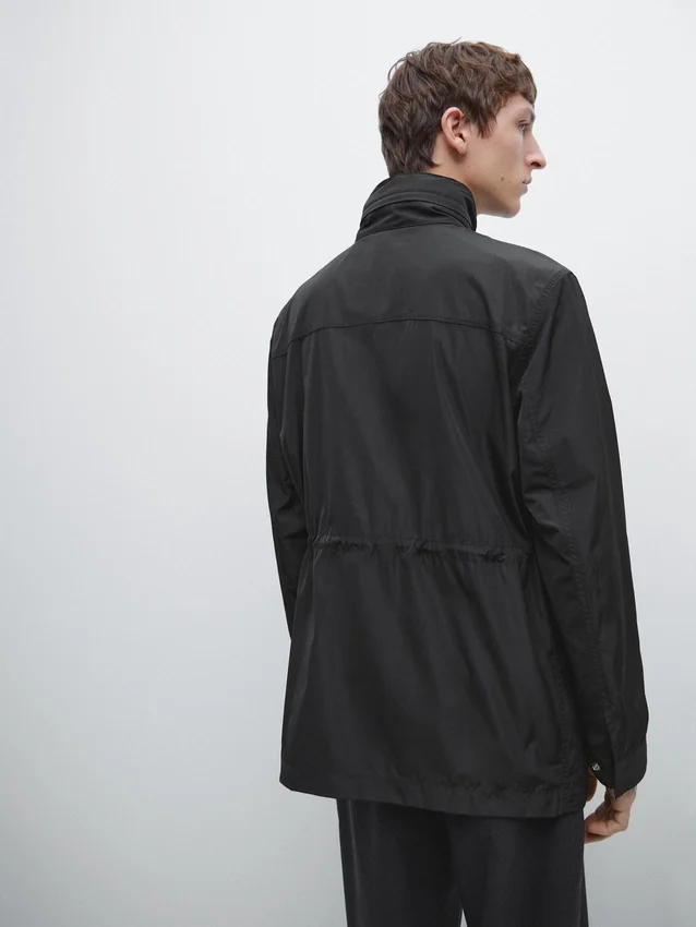 Parka med hette og stoffdetaljer Parka med hette og stoffdetaljer
